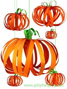 some orange paper pumpkins hanging from strings