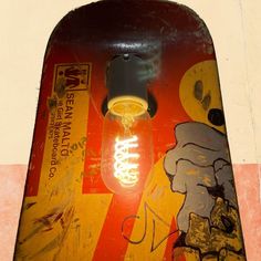 an old skateboard with a light bulb on it's end and graffiti painted on the side