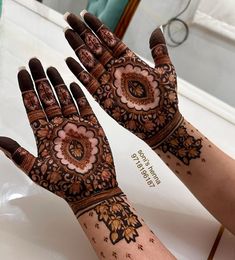 two hands with henna designs on them