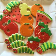 some very pretty decorated cookies in the shape of fruits and veggies on a plate