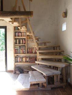 a staircase made out of wood with bookshelves on each side and benches underneath