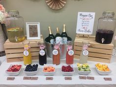 a table topped with bottles of wine and bowls of fruit