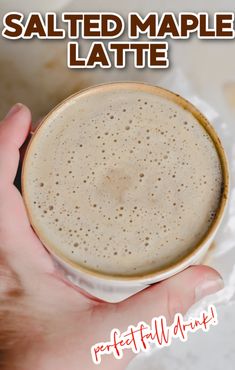 a hand holding a cup of salted maple latte