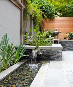 a small garden with a waterfall and water feature