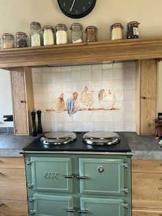 an old fashioned stove in a kitchen with lots of jars on the top shelf above it