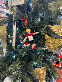 an ornament hanging on a christmas tree with angel ornaments in the foreground