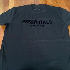 Essentials Black New T-Shirt Size Small Essential Shirts For Men, Essential Streetwear T-shirt With Logo Print, Basic Black T-shirt For Streetwear, Essential Short Sleeve Graphic T-shirt, Essential Short Sleeve T-shirt With Graphic Print, Essential Graphic Print Short Sleeve T-shirt, Black Essential T-shirt With Relaxed Fit, Urban Black Tops With Text Print, Black Text Print Top For Streetwear