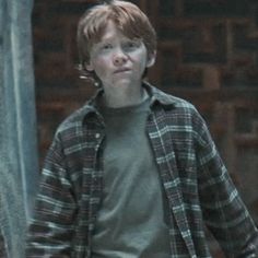 a young boy standing in front of a building