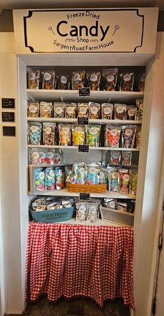 a display case filled with lots of candy and other items in front of a sign