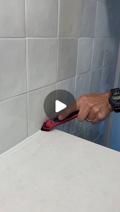 a person using a pair of pliers to cut tile on a bathroom counter top