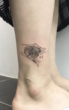 a small tattoo on the ankle of a woman with an elephant in it's head