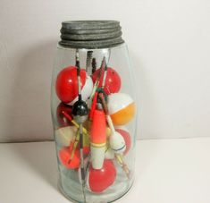 a glass jar filled with lots of different types of candies and lollipops