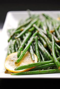 a white plate topped with green beans and orange slices