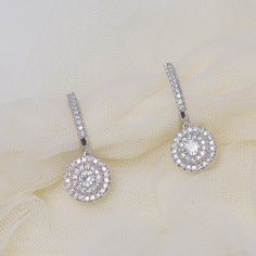 The 2 tone hoop drop diamond earring divulges two round diamonds trapped at the hub, surrounded by two circles of petite diamonds settled in prong setting. Along with hinge clasps, the hoops are studded with diamonds, and the casing of center diamond is decorated with floral motifs. The round double halo hoop earrings showcases two round cut diamonds of excellent quality of 0.50 carat each, SI1 clarity and H color held steadfastly in prong setting. Series of round cut diamonds of SI2 clarity and G color and 0.65 carat total weight are implanted surrounding the center diamonds and along the hoop in prong setting. The round diamond two tone hoop earrings can also be acquired in numerous other metals. Total number of diamonds – 82. Total carat weight – 1.65 CTW. Conflict Earrings Diamonds, Womens Earrings, Tear Drops, Diamond Earring, Women Diamond, Classic Jewelry, Diamond Drops, Best Diamond, Diamond Drop Earrings