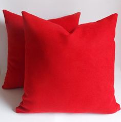 two red pillows sitting next to each other