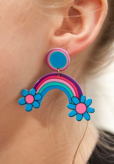 a close up of a person wearing some kind of earring with flowers on it