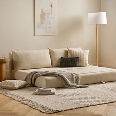 a living room scene with focus on the corner sofa and throw pillows that have been placed on the floor