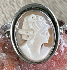 FREE SHIPPING to all US addresses!  This listing is for a handmade sterling silver ring with an oval cameo bezel set cabochon.  The cameo base is a traditional shell carved head in profile. It measures 8  1/2 on the mandrel . Probably European made in the 1950's to 60's. It is stamped '9250 on the outer ring band.  The ring has its original lovely soft patina. It could be polished if so desired. Please see my other listings-- I have just started adding a large number of vintage jewelry items to Oval Silver Cabochons For Gift, Classic Oval Cameo Jewelry, Classic Oval Cameo Rings, Classic Silver Oval Cabochons, Classic Oval Silver Cabochons, Antique Silver Cameo Rings, Vintage Oval Cameo Ring, White Oval Cameo Jewelry, White Oval Rings With Intaglio