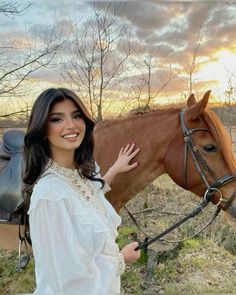 a woman standing next to a brown horse