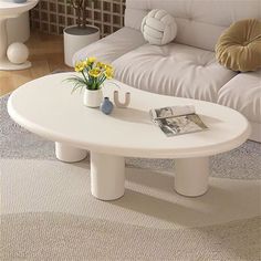 a white coffee table sitting on top of a carpeted floor next to a couch