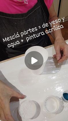 a woman in an apron is making some food on a tray with plastic wrappers