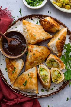 a plate filled with pastries and dipping sauce