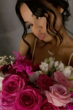 a woman sticking her tongue out next to a bouquet of flowers