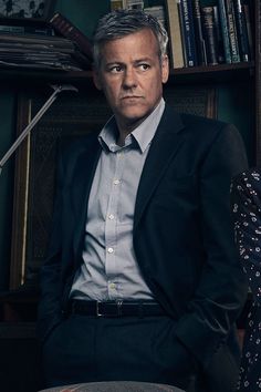 a man sitting in front of a book shelf