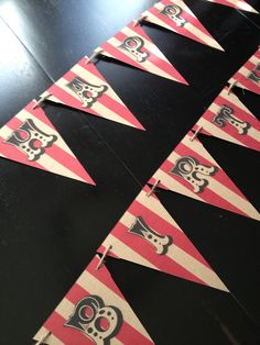 a black table topped with red and white pennants filled with cartoon character symbols on it