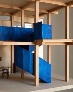 a blue sculpture sitting in the middle of a room next to a table and chairs