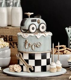 a birthday cake with a car on top and some cookies around the edges for decoration