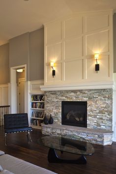 a living room filled with furniture and a fire place in front of a book shelf