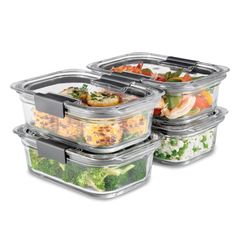 four plastic containers with food in them sitting on top of each other and one is filled with vegetables