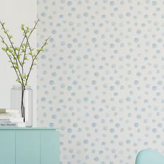 a vase filled with flowers sitting on top of a blue dresser next to a wall