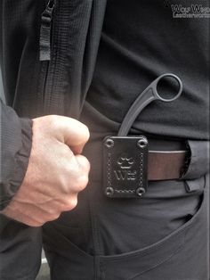 a close up of a person holding a pair of scissors in their pocket with the other hand