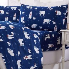 a bed covered in blue and white polar bear comforters with snowflakes on them