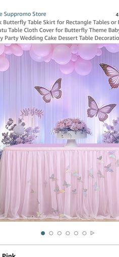 an image of a table with pink flowers and butterfly decorations on it for a party