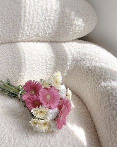 a bouquet of flowers sitting on top of a white blanket