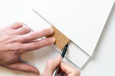 a man is cutting out a piece of paper with a pair of scissors on it