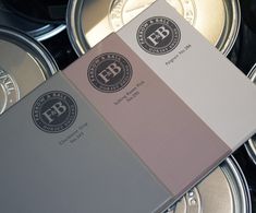 the back side of a book sitting on top of some silver tins with black and white logos