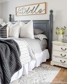 a bed with white and black pillows in a bedroom