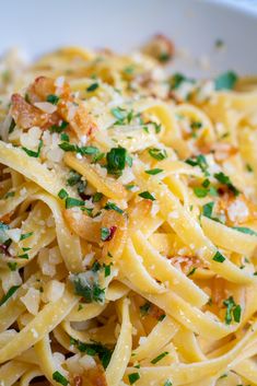 a white bowl filled with pasta and parmesan cheese