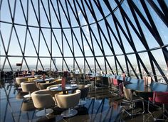 the inside of a building with tables and chairs on it's glass flooring