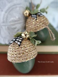 two green vases decorated with burlocks and gold foiled bows are sitting next to each other