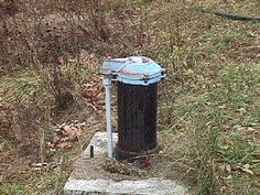 an old fire hydrant sitting in the middle of a field next to some grass