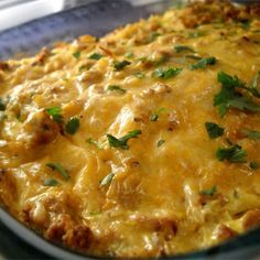 a casserole dish with meat and cheese on top, garnished with parsley