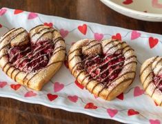 three heart shaped pastries sitting on top of a white plate