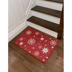 a red door mat with white snowflakes on it in front of some stairs