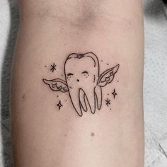 a tooth with angel wings and stars on the side of his right arm, which is drawn in black ink