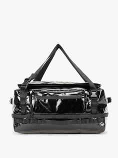 a black and silver handbag with straps on it's side, in front of a white background